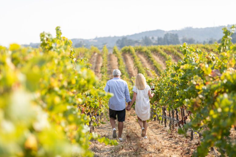 Couple walking through vineyards.